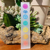A clear wand bar with multicolored geometric chakra symbols painted along its length.