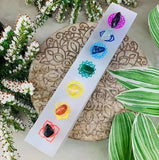 A crystal bar with gemstones placed on each chakra symbol.