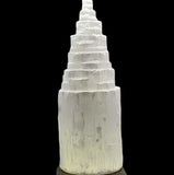 An extra-large monolith crystalline with a layered, cylindrical shape, predominantly white in color. It is displayed against a dark background.